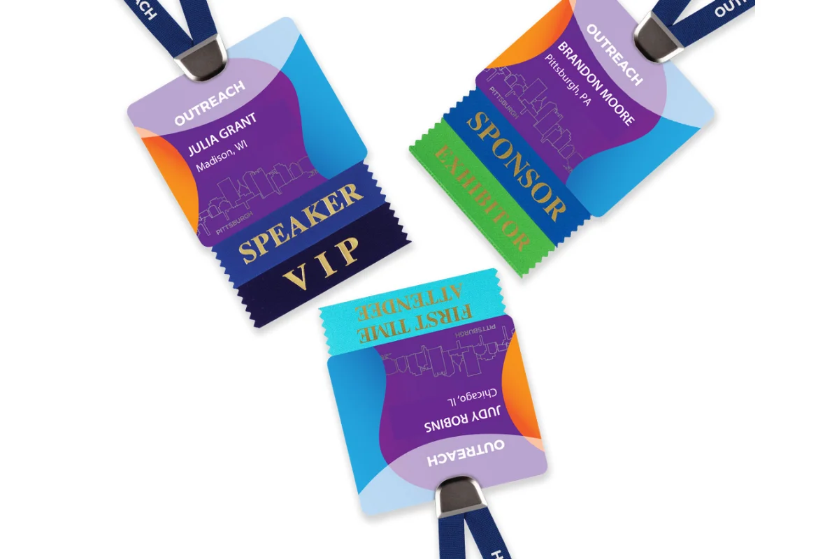 Three event badges with ribbon attachments marking Speaker/VIP, Sponsor/Exhibitor, and First Time Attendee.